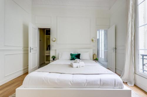 une chambre blanche avec un grand lit blanc dans l'établissement L'émeraude - Neuf & Calme -Opéra & Grands Magasins, à Paris