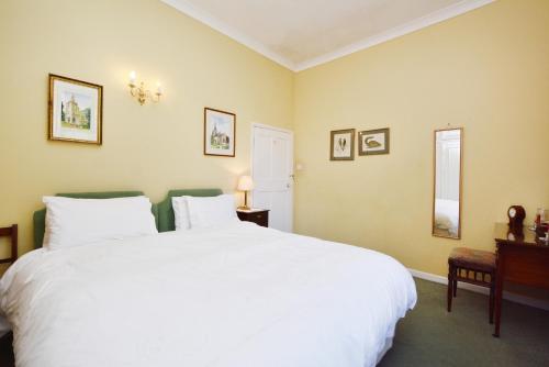 a bedroom with a large white bed and a window at The Old School in Bicester