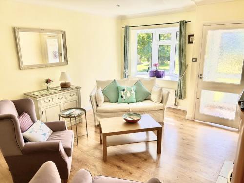 een woonkamer met twee banken en een tafel bij Daisy Cottage by NewFo rest in Lymington