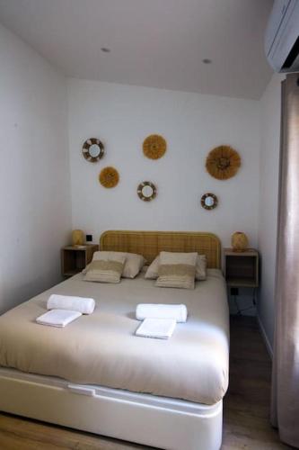 une chambre avec un lit blanc avec des serviettes dessus dans l'établissement La petite maison du Rouet, à Marseille