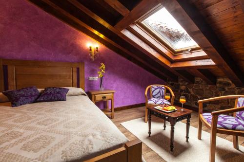 a bedroom with purple walls and a bed and a table at Hotel Spa Casona La Hondonada in Terán