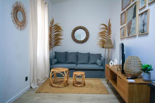 - un salon avec un canapé bleu et deux tabourets dans l'établissement La petite maison du Rouet, à Marseille