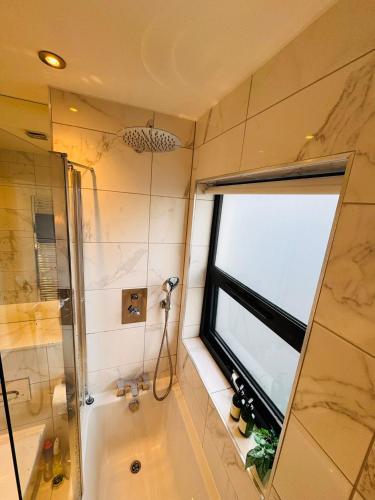 a bathroom with a shower and a tub and a window at #13 Elegant Solihull Townhouse - Sleeps 10 - NEC BHX - "Perfect for Contractors and Families - Fee Parking in Olton