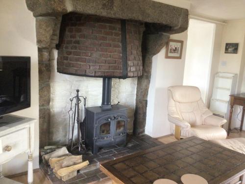- un salon avec une cheminée et une cuisinière dans l'établissement La sourdine, à Sourdeval