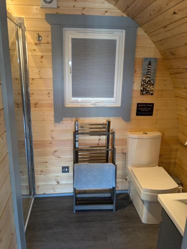 a small bathroom with a toilet and a window at Robins Nest Pod in Breakish