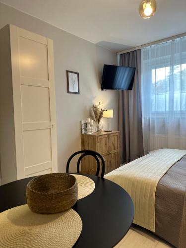 a bedroom with a bed and a table and a bed and a tv at APARTAMENTY LAVENDERIA z widokiem na Górę Parkową, blisko centrum in Kudowa-Zdrój