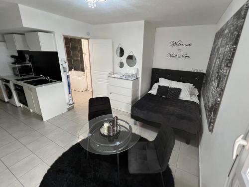 Cette chambre comprend un lit, une table et une cuisine. dans l'établissement Malt&SPA jacuzzi privatif, à LʼIsle-dʼAbeau