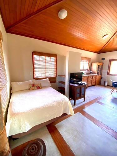 a bedroom with a bed and a wooden ceiling at Hospedagem Tulipane - Praia do Campeche in Florianópolis