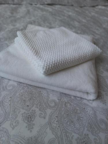 two white towels sitting on top of a bed at Smart Stay Odžaci in Odžaci