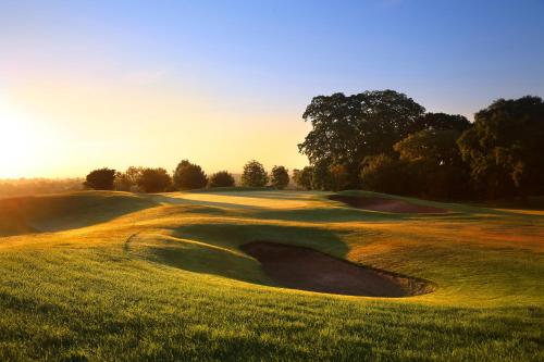 a golf course with a hole in the grass at Macdonald Portal Hotel, Spa & Golf Resort in Tarporley