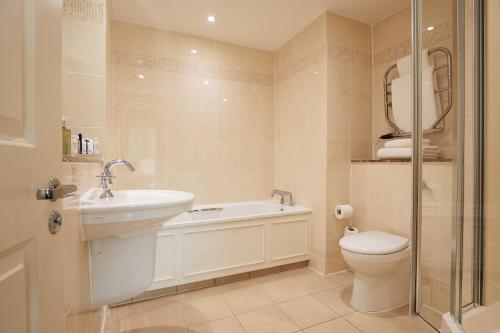 a bathroom with a sink and a toilet and a shower at Macdonald Portal Hotel, Spa & Golf Resort in Tarporley