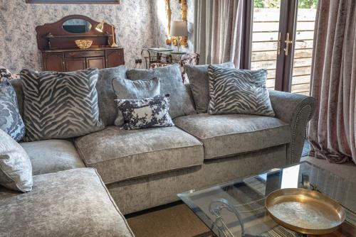 a living room with a couch with zebra pillows at Clover 20 Lodge, Yellowtop Country Park in Selby