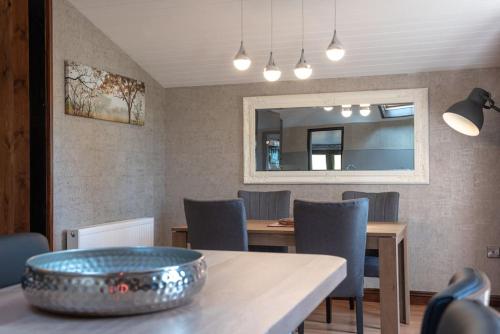 a dining room with a table and chairs and a mirror at Clover 20 Lodge, Yellowtop Country Park in Selby