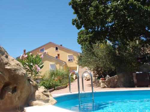 une piscine devant une maison dans l'établissement Apartments Dumicic, à Rab