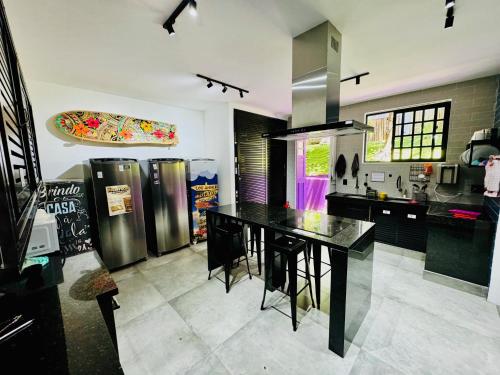 a kitchen with a black table and some stainless steelzers at Pura Vida Hostel in Rio de Janeiro