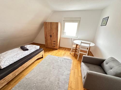 a bedroom with a bed and a couch and a table at W24 - 8 Einzelbetten - 6 Schlafzimmer - Wohnzimmer & große Terrasse - 2 Bäder - Wohnung auf 2 Ebenen - Nähe Messe Stuttgart & A81 - Ideal für Teams & Monteur in Böblingen