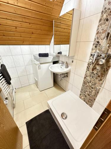 a white bathroom with a sink and a shower at W24 - 8 Einzelbetten - 6 Schlafzimmer - Wohnzimmer & große Terrasse - 2 Bäder - Wohnung auf 2 Ebenen - Nähe Messe Stuttgart & A81 - Ideal für Teams & Monteur in Böblingen