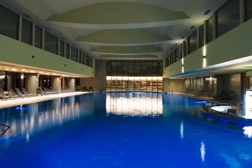 a large pool with blue water in a building at Hotel Piatra Mare in Poiana Brasov