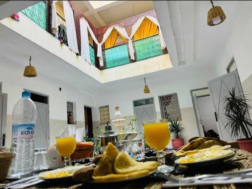 una mesa con platos de comida y vasos de jugo de naranja en marrakesh riad, en Marrakech