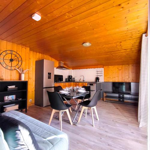 une cuisine et un salon avec une table et des chaises dans l'établissement T2 tout confort avec balcon au calme entre lac et montagne, à Brizon
