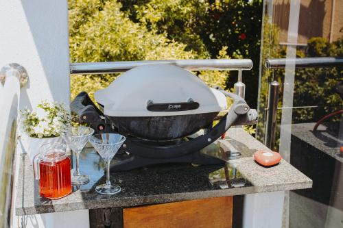 a grill sitting on a table with glasses on it at 185 on BEACH Boutique Suites in Gordonʼs Bay