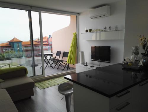 a kitchen and living room with a view of a patio at Ventur Balcony in Caniço