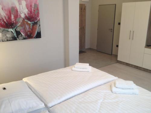 a bedroom with two white beds and a painting on the wall at Pension Phoenix in Znojmo
