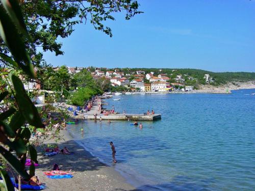 a group of people on a beach in the water at Apartments Andelka G in Šilo