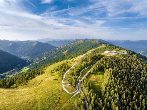 a winding road on top of a hill with trees at COOEE alpin Hotel Bad Kleinkirchheim in Bad Kleinkirchheim