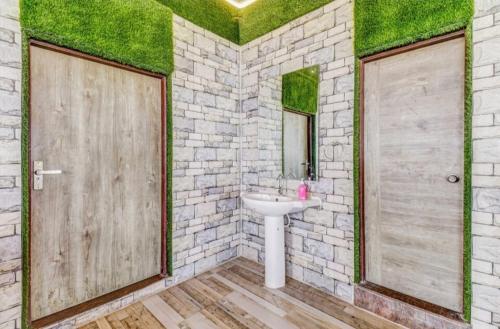 ein Badezimmer mit einem weißen Waschbecken und einer Steinwand in der Unterkunft Lutino Homes Ramurthynagar main Road opposite D Mart in Bangalore