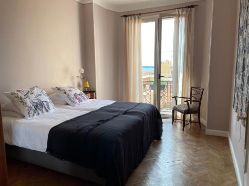 une chambre avec un lit et une grande fenêtre dans l'établissement Palais Gothique, à Cannes