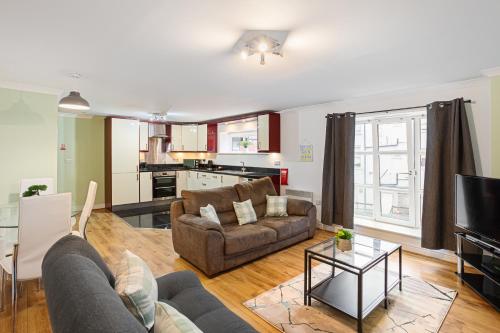a living room with a couch and a table at Bookbinders Apartments Leeds City Centre in Leeds