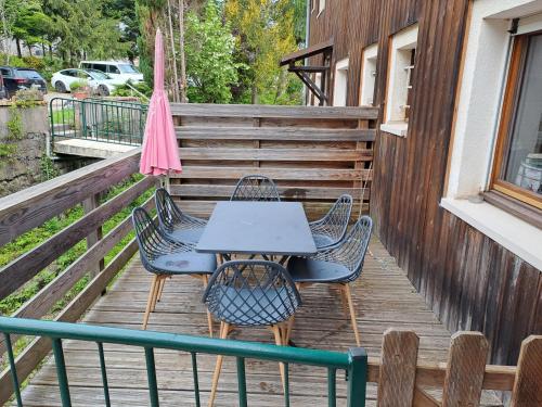 une table et des chaises sur une terrasse avec un parasol dans l'établissement Appartement 41m2, à Gérardmer