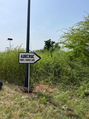 a street sign on a pole in a field at Auberge Andel Diabou SARR in Palmarin