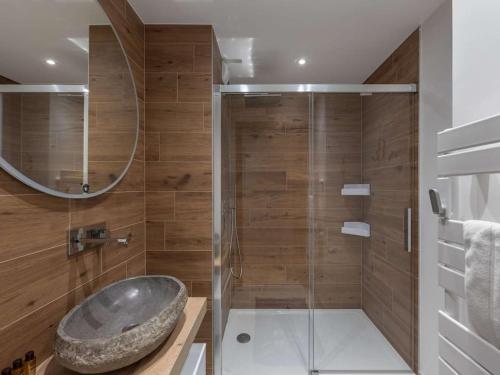 La salle de bains est pourvue d'une douche et d'un lavabo en pierre. dans l'établissement Apt Thélème 102 - BO Immobilier - Châtel, à Châtel