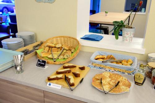 un buffet con pan y bollería en una barra en Hotel ASTORIA- Saint Etienne-Centre des Congrès-, en Saint-Étienne