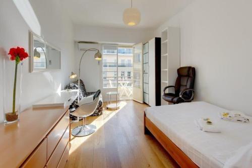 une chambre avec un lit et un bureau avec une chaise dans l'établissement MyrAzur Carre d'Or, à Nice