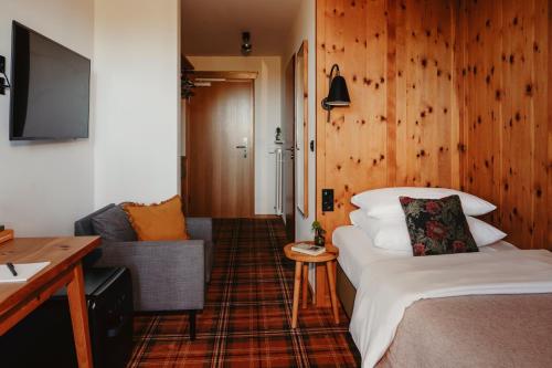 a hotel room with a bed and a couch at Hotel Bussi Baby in Bad Wiessee