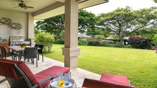 a patio with a table and chairs and a lawn at Villages At Mauna Lani 621 in Waikoloa