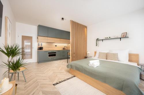 a bedroom with a large bed and a kitchen at Internesto Brno Urban in Brno