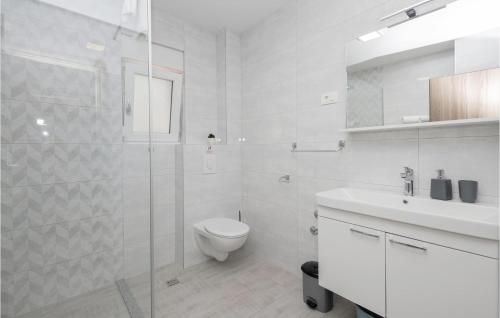 a white bathroom with a toilet and a sink at 2 Bedroom Gorgeous Apartment In Podaca in Podaca