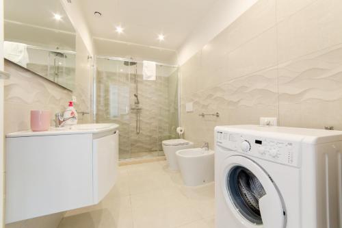 a white washing machine in a bathroom with a toilet at Diva Luxury Suite in Torre San Giovanni Ugento