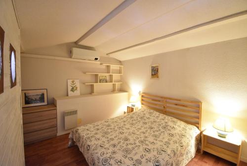 - une chambre avec un lit et deux lumières sur deux tables dans l'établissement Point d'or L22 - Hossegor à la plage sud, à Soorts-Hossegor