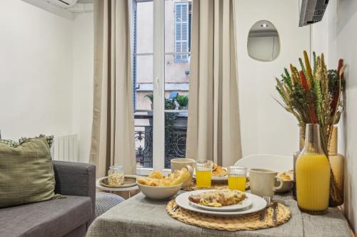 - un salon avec une table, de la nourriture et du jus d'orange dans l'établissement Rivages du Vieux Port, à Marseille