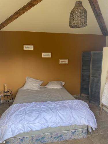- une chambre dotée d'un lit avec un mur brun dans l'établissement Chambre équipée, à Saint-Maximin-la-Sainte-Baume