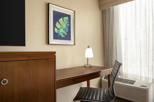 a hotel room with a desk and a chair at Doubletree by Hilton Fort Myers at Bell Tower Shops in Fort Myers