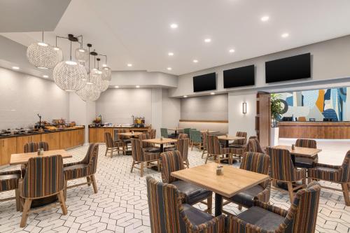 a restaurant with tables and chairs in a room at Doubletree by Hilton Fort Myers at Bell Tower Shops in Fort Myers