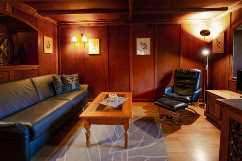 a living room with a couch and a chair at Hoglhaus & Malerwinkel in Mittenwald