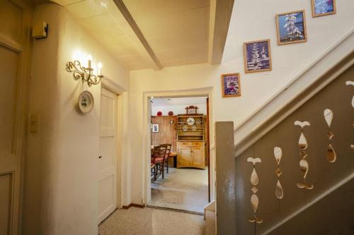 a hallway with stairs and a dining room in a house at Hoglhaus & Malerwinkel in Mittenwald