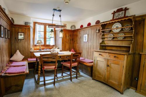 a dining room with a table and chairs and a kitchen at Hoglhaus & Malerwinkel in Mittenwald
